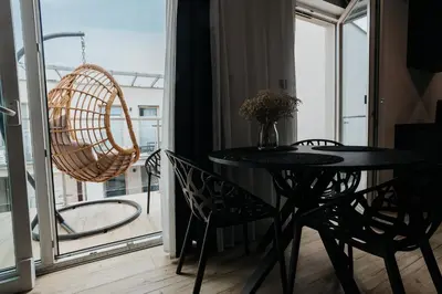 a table and chairs in a room with a balcony at Cubicle 72 Studio Big Terrace in Kraków