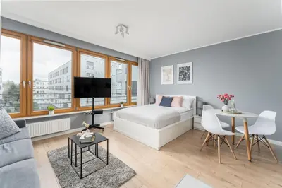 a living room with a bed and a table at Vistula Boulevard Apartment with free parking spot in Kraków