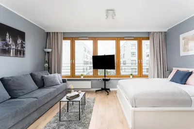 a living room with a bed and a couch at Vistula Boulevard Apartment with free parking spot in Kraków