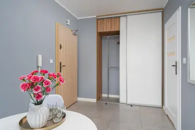 a room with a vase of flowers on a table at Vistula Boulevard Apartment with free parking spot in Kraków