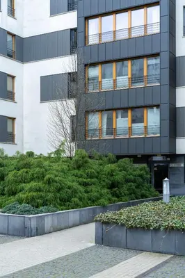 a building with a garden in front of it at Vistula Boulevard Apartment with free parking spot in Kraków