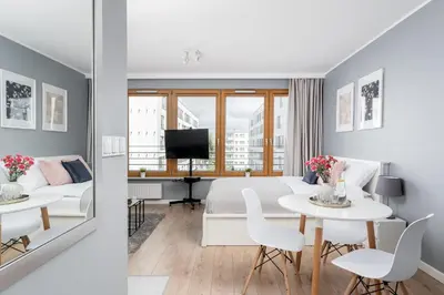 a bedroom and a living room with a bed and a table at Vistula Boulevard Apartment with free parking spot in Kraków