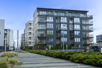 a tall building with glass windows in a city at Vistula Boulevard Apartment with free parking spot in Kraków