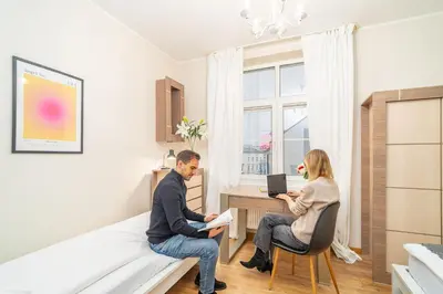 two people sitting at a desk in a room at Bayview on Długa - By Hosty in Kraków