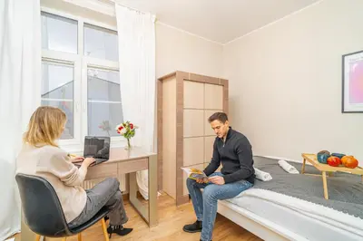 a man and a woman sitting at a desk in a room at Bayview on Długa - By Hosty in Kraków
