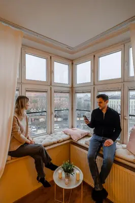 a man and a woman sitting on a window sill at Bayview on Długa - By Hosty in Kraków