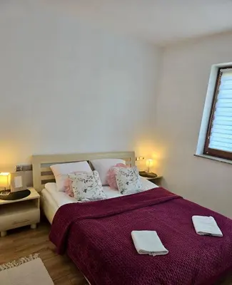 a bedroom with a bed with two towels on it at Widokówka Kudłacze Domek z Jacuzzi in Pcim