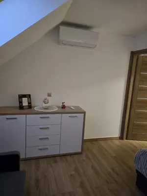 an attic room with a white cabinet and a staircase at Widokówka Kudłacze Domek z Jacuzzi in Pcim