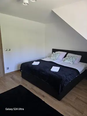 a bedroom with a bed with black sheets and pillows at Widokówka Kudłacze Domek z Jacuzzi in Pcim