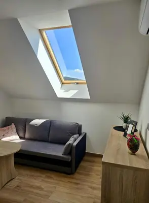 a living room with a couch and a window at Widokówka Kudłacze Domek z Jacuzzi in Pcim