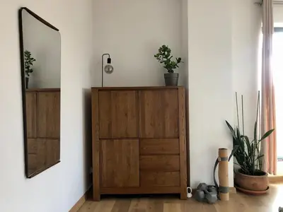 a mirror and a wooden cabinet in a room at KrakowCharm private apartment Old Town in Kraków