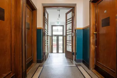 an empty hallway with wooden doors and a hallwayngth at KrakowCharm private apartment Old Town in Kraków