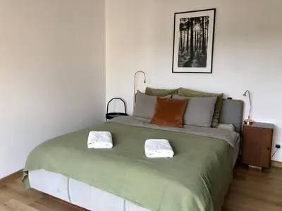 a bedroom with a large bed with two towels on it at KrakowCharm private apartment Old Town in Kraków