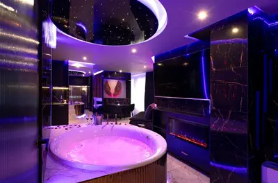 a bathroom with a large tub in a purple room at Jacuzzi Glass-House Wislane Tarasy with Sauna and Parking in Kraków