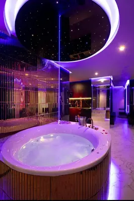 a large bathroom with a large tub with purple lighting at Jacuzzi Glass-House Wislane Tarasy with Sauna and Parking in Kraków