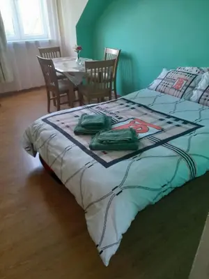 a bedroom with a bed and a table and chairs at apartament przytulny in Ogrodzieniec