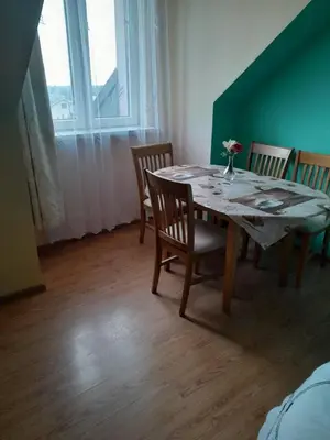 a kitchen with a white refrigerator and wooden cabinets at apartament przytulny in Ogrodzieniec