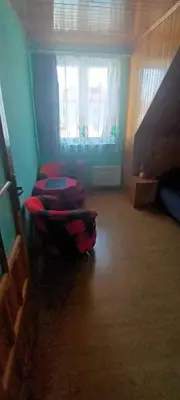 a bed with a red and black comforter in a room at apartament przytulny in Ogrodzieniec