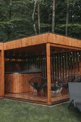 a group of chairs sitting on a deck with a grill at W szczerym lesie - Domek z sauną i jacuzzi w lesie nad Jeziorem Mucharskim in Dąbrówka