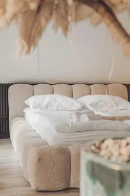 a bed with white sheets and pillows in a room at W szczerym lesie - Domek z sauną i jacuzzi w lesie nad Jeziorem Mucharskim in Dąbrówka