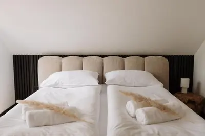 two beds with white sheets and white pillows at W szczerym lesie - Domek z sauną i jacuzzi w lesie nad Jeziorem Mucharskim in Dąbrówka