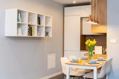 a kitchen and dining room with a table and chairs at Mieszkanie na Groblach in Kraków