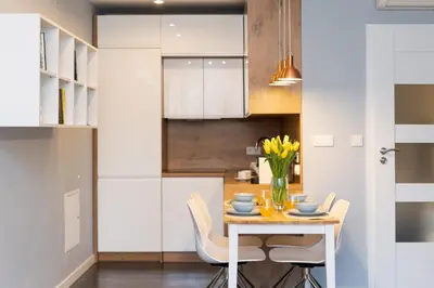 a kitchen and dining room with a table and chairs at Mieszkanie na Groblach in Kraków