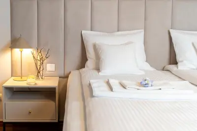 a hotel room with two beds and a table with a night stand at Tarlowska - Free Parking - Near Castle, Main Square & River - 3 bedroom, loggia, 2xTV 4K in Kraków