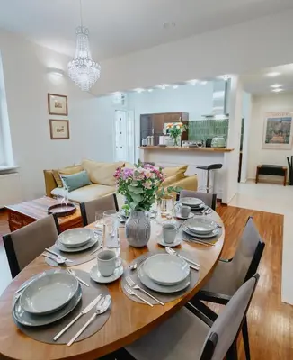 a dining room with a table with plates and silverware at Tarlowska - Free Parking - Near Castle, Main Square & River - 3 bedroom, loggia, 2xTV 4K in Kraków