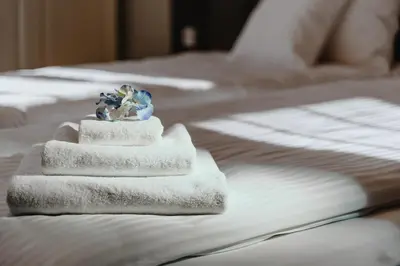 a pile of towels sitting on top of a bed at Tarlowska - Free Parking - Near Castle, Main Square & River - 3 bedroom, loggia, 2xTV 4K in Kraków