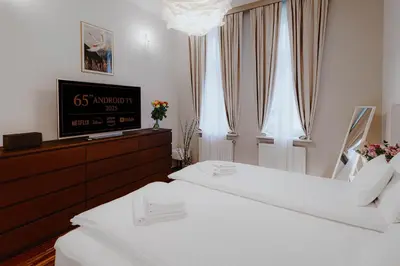 a bedroom with two beds and a flat screen tv at Tarlowska - Free Parking - Near Castle, Main Square & River - 3 bedroom, loggia, 2xTV 4K in Kraków