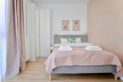 a bedroom with a bed with a pink blanket at Mama's Home Krakow in Kraków
