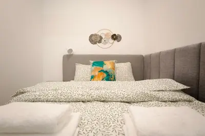 a bedroom with a bed with a gray headboard at Mama's Home Krakow in Kraków