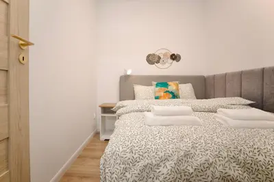 a bedroom with a bed with a gray headboard at Mama's Home Krakow in Kraków
