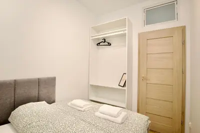 a bedroom with a bed with two white towels on it at Mama's Home Krakow in Kraków