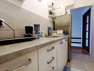 a kitchen with a sink and a clock on the wall at Pokoje Krakow Plus in Kraków