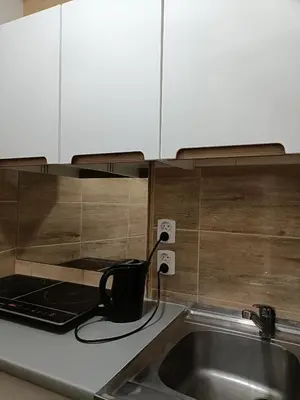a kitchen counter with a sink and a black tea kettle at Pokoje Krakow Plus in Kraków