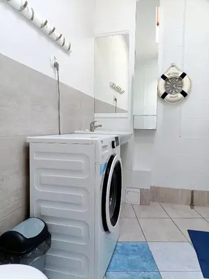 a bathroom with a washing machine and a sink at Pokoje Krakow Plus in Kraków