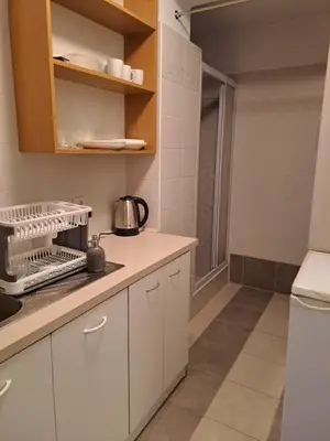 a kitchen with white cabinets and a counter top at Słoneczna Pleszowska in Kraków