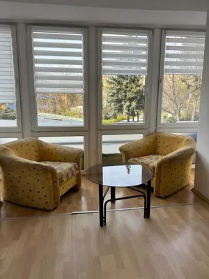a living room with two couches and a table and windows at Słoneczna Pleszowska in Kraków