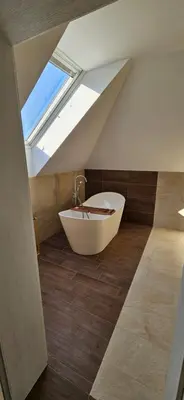 a bath tub in a bathroom with a skylight at Villa Kozikowka lake and forest near Krakow and Wieliczka in Ulesie