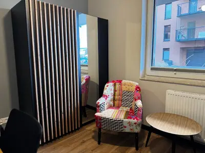 a living room with a chair and a radiator at Salsa Apartament in Kraków