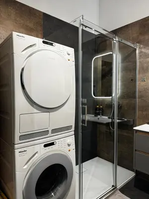 a washing machine in a bathroom with a shower at Salsa Apartament in Kraków