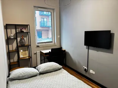 a bedroom with a bed and a desk and a window at Salsa Apartament in Kraków