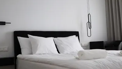 a bedroom with a bed with white sheets and pillows at Klimieckiego 8A BW Apartments in Kraków