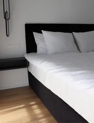 a bed with white sheets and pillows in a room at Klimieckiego 8A BW Apartments in Kraków