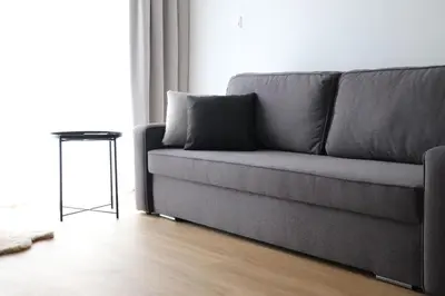 a gray couch in a living room with a table at Klimieckiego 8A BW Apartments in Kraków