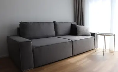 a gray couch in a living room with a table at Klimieckiego 8A BW Apartments in Kraków