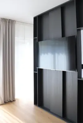 a black book shelf in a room with a window at Klimieckiego 8A BW Apartments in Kraków