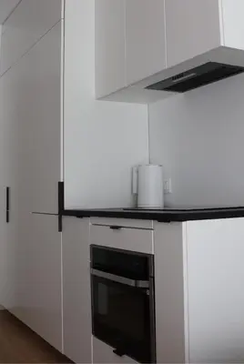 a kitchen with white cabinets and a black oven at Klimieckiego 8A BW Apartments in Kraków